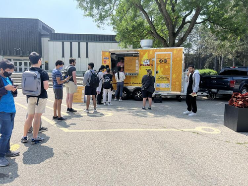 Students line up to buy food from a food truck in the Arts Quad.
