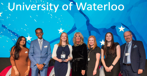 Representatives from the University of Waterloo and the United Way stand together on stage with the awards.