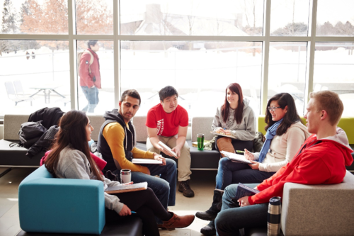 Students sitting on couches in a lounge setting.