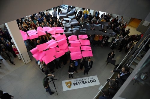 Participants form the HeForShe logo by holding up coloured placards.
