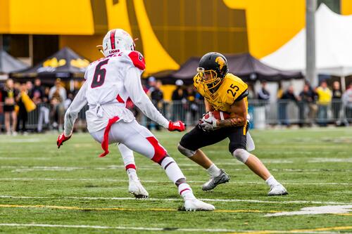 A Waterloo Warriors football player attempts to get around a York defenceman.