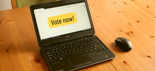 A laptop with the phrase &quot;vote now&quot; on its screen.