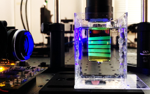 Tomographic printing in process - light is bounced off a vial inside a goopy bath.