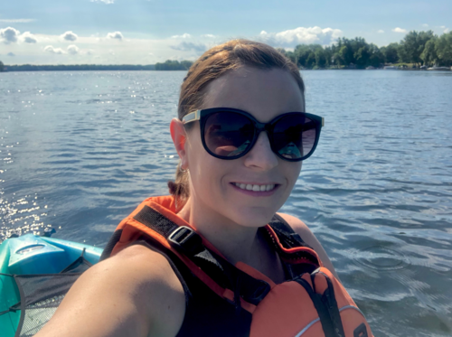 Dr. Megan McCarthy wears a life jacket while kayaking on a lake.
