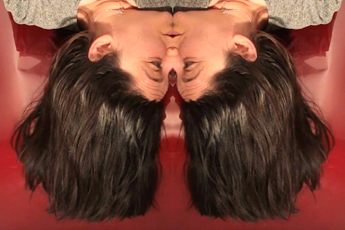A mirror image of a woman's face in profile.