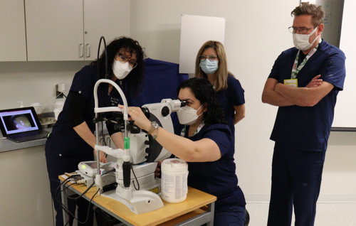 Instructor Dr. C. Lisa Prokopich (left) instructs participants on laser peripheral iridotomy techniques