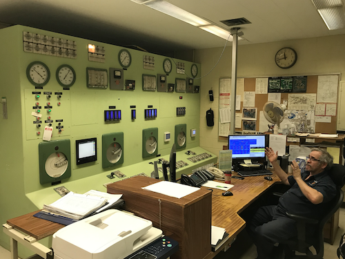 Tom Williams of Plant Operations keeps watch on the boiler control panel.