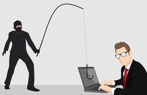 A masked hacker dangles a hook in front of a laptop user.