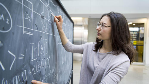 Professor Anna Golubeva writes on a blackboard.