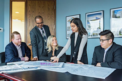 Debra Kakaria and colleagues at work in a MacNaughton Hermsen Britton Clarkson Planning Limited promotional photo.
