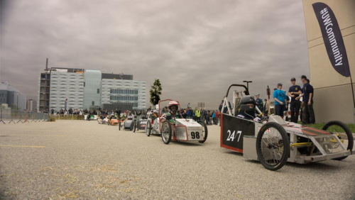 Electric race vehicles line up with Engineering 5 in the background.