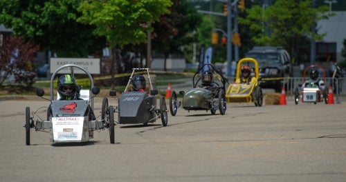 Electric race cars on the track outside East Campus 5.