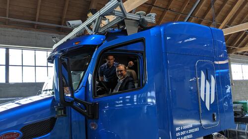 Feridun sits in the cab of an Embark truck.