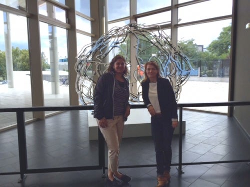 Myra Fernandes and Helen Sauzeon pose in front of a model depicting the neuroanatomical structure of the brain at the University of Bordeaux’s Neurosciences Unit.