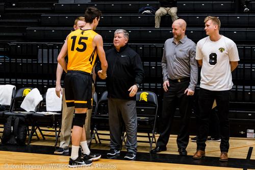 Chris Lawson congratulations a Waterloo Warriors volleyball player from the sidelines.