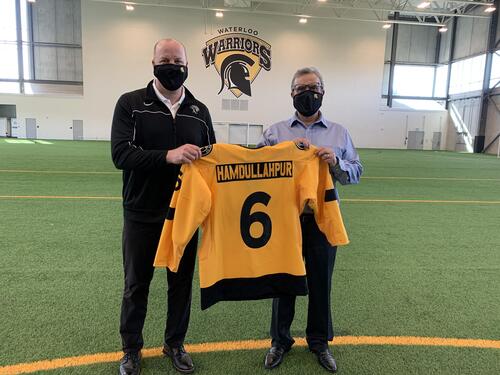 Roly Webster (left), Director of Athletics and Recreation, presents Feridun with a personalized jersey.