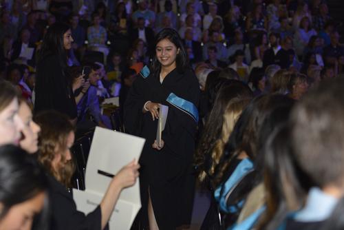 An Applied Health Sciences student returns to her seat after receiving her degree.