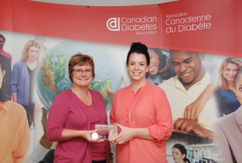 Women standing in front of the Diabetes Association banner.