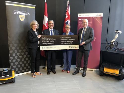 Feridun Hamdullahpur, Sandra Banks, and National Research Council representatives hold a sign outlining the new partnership.