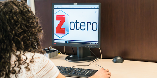 A woman uses a computer with the Zotero software on screen.