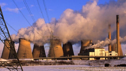 A power plant with cooling towers belching steam.