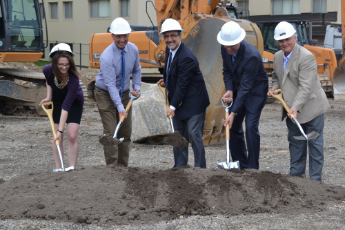 Waterloo representatives plant shovels in the dirt at the residence groundbreaking ceremony.