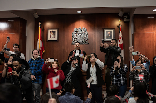 Judge Albert Wong presides over a cheer during a citizenship ceremony.