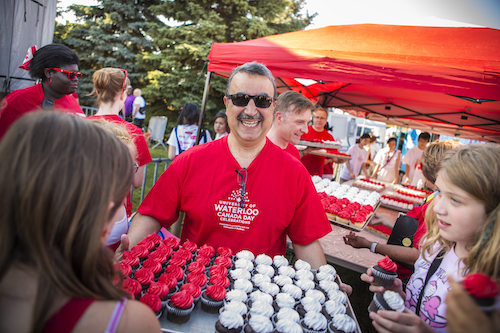 Feridun Hamdullahpur with a tray of red-and-white cupcakes at the University of Waterloo Canada Day celebrations in 2012.