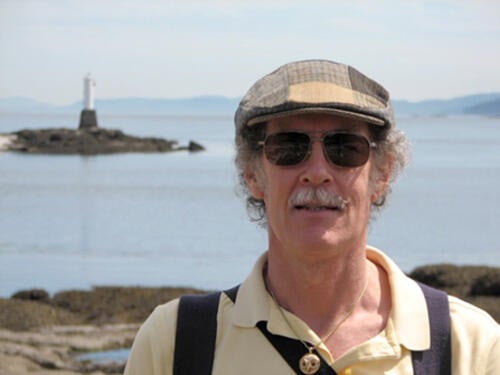 Professor John Beatty on Gabriola Island with a lighthouse in the background.