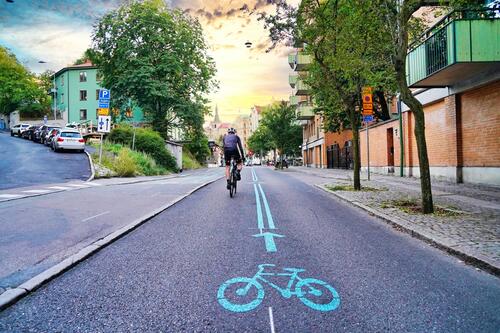 A cyclist cycles in a separated bike lane in Europe.