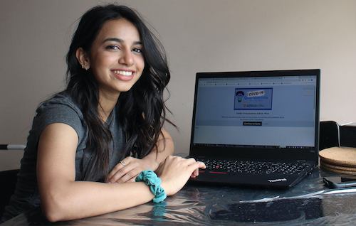 Ridhi Patel sits with a laptop featuring her video game.