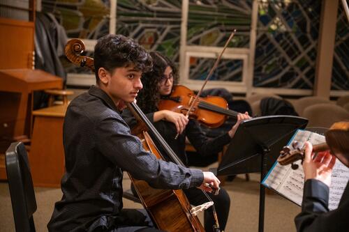 Two members of the Chamber Ensemble playing stringed instruments.