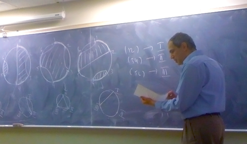 Alexandru Nica teaches in front of a blackboard.