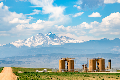 Oil extraction operation in the shadow of mountains in Colorado.