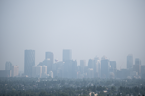 A city skyline obscured by wildfire smoke.