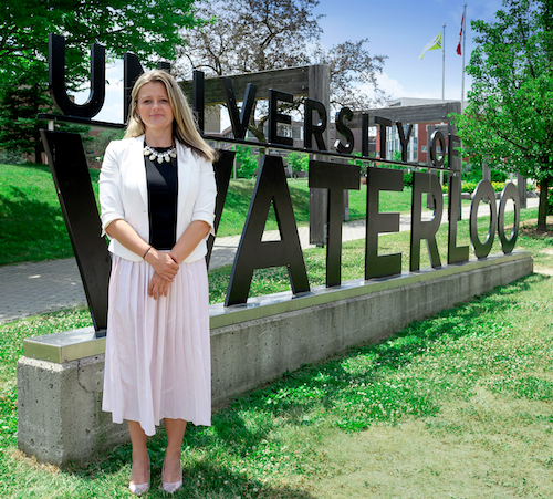 Camelia Nunez stands next to the University of Waterloo south campus sign.