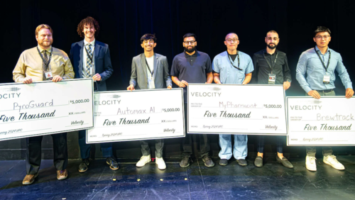 Velocity Pitch Competition winners stand with their oversized cheques.