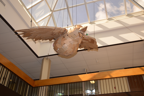 A three-dimensional model of the Cerulean Warbler made from repurposed cardboard hangs in a building atrium.