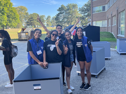 Residence move-in volunteers in a group photo with a moving bin.