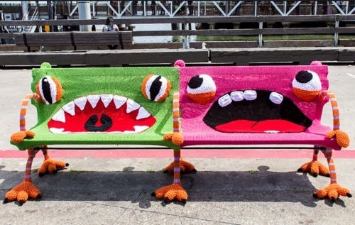 A park bench &quot;yarn bombed&quot; to look like a pair of creatures.