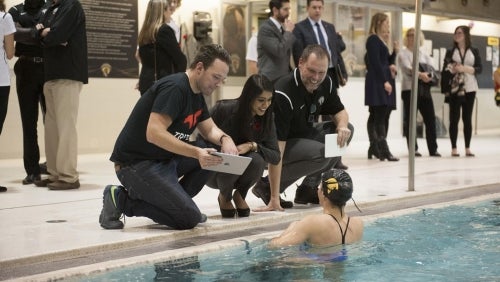 Swimming coach Jeff Slater (right) and MP Bardish Chagger speak with Warrior swim team member.
