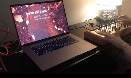 Lyrics are generated on a laptop screen as a person plays a desktop synthesizer.