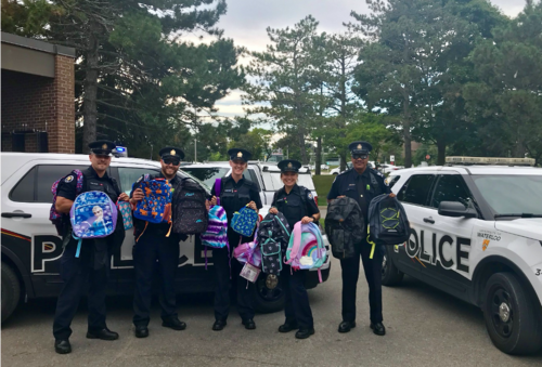 University Police stand with backpacks.