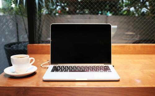 A laptop with a cup of coffee