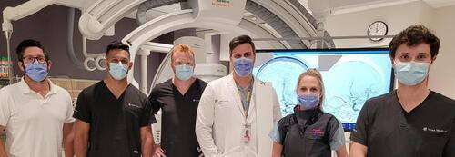 Michael Phillips, third from left, and Phillip Cooper, right, of Vena Medical pose with a colleague and medical officials at the London Health Sciences Centre in London after the first use of a new device to remove blood clots in the brains of stroke victims.