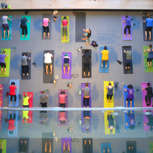 Top-down shot of people practicing yoga on colourful mats