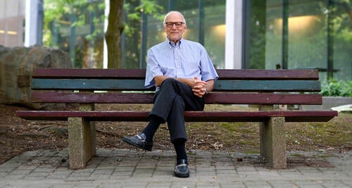 University Professor Tamer Ozsu sits on a bench.
