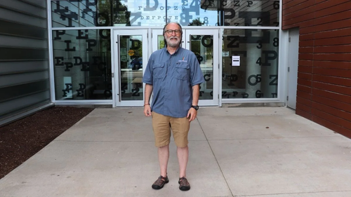 Dr. Trefford Simpson stands in front of the School of Optometry.