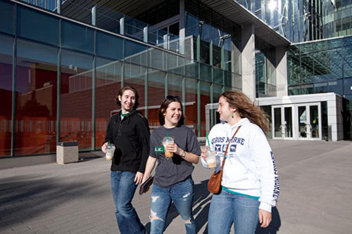Students walking and talking in front of the Quantum-Nano Centre.