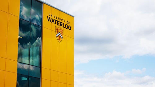 The exterior of the CIF Field House showing the University of Waterloo shield.